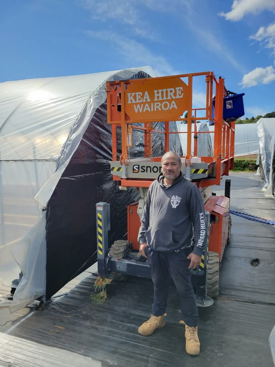 A whānau member on site during greenhouse construction