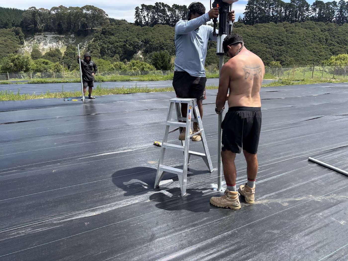 The crew driving greenhouse foundations into the covered ground